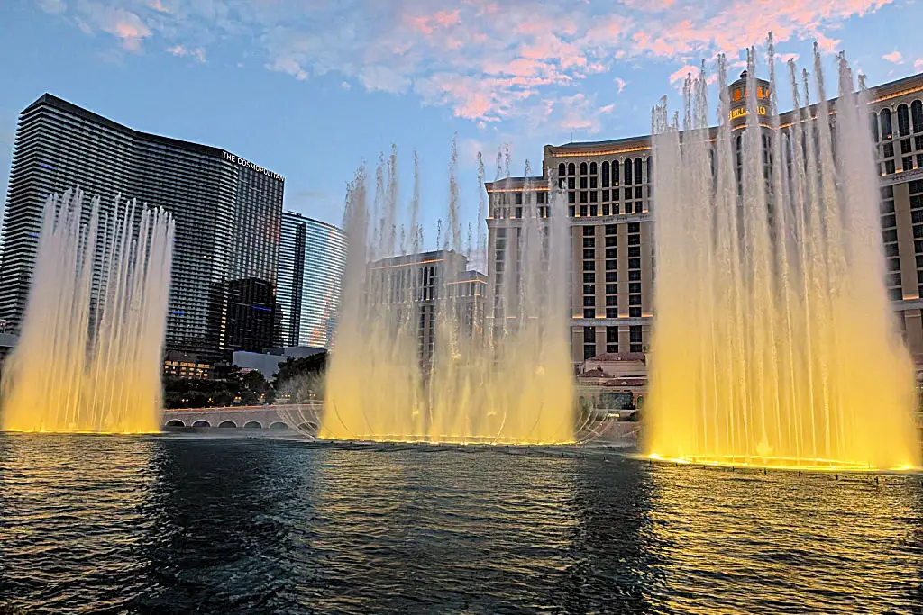 bellagio fountains with bellagio and cosmopolitan in background at sunset