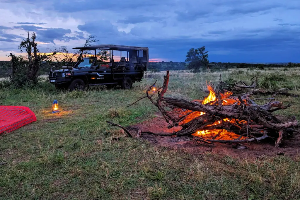 klein's camp in tanzania &beyond campfire with lantern and blankets at sunset